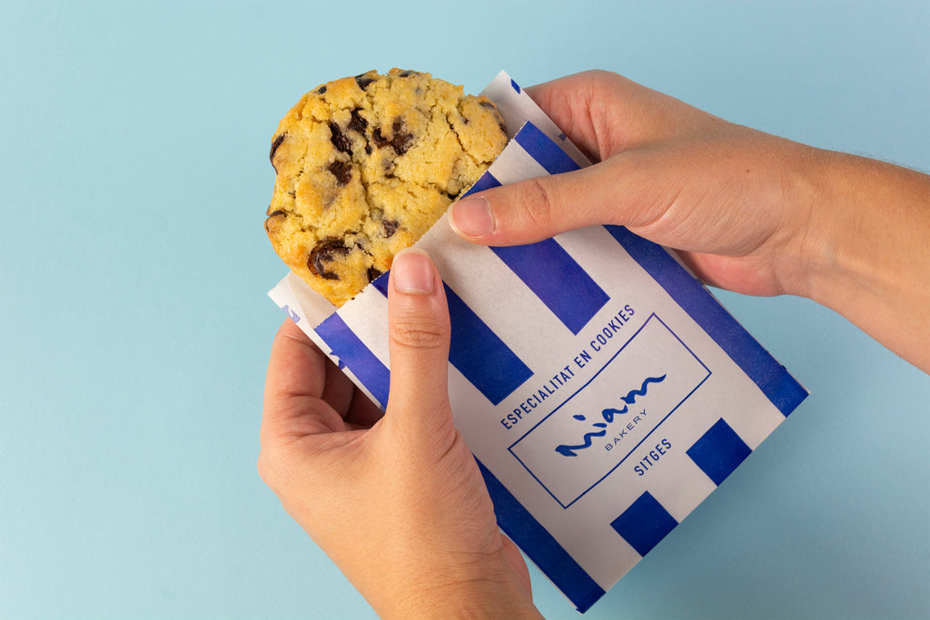 Cookie clásica de chips de chocolate negro en su sobre de papel