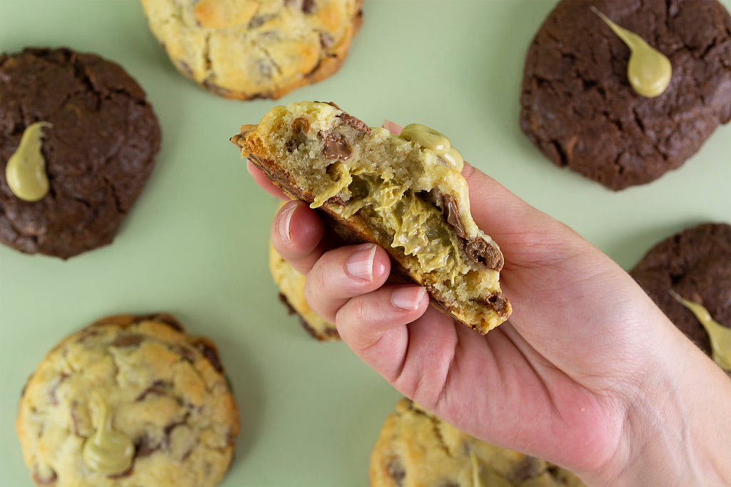 Cookie Dubai en la mano, con interior de crema de pistacho, kataifi tostado y tahini